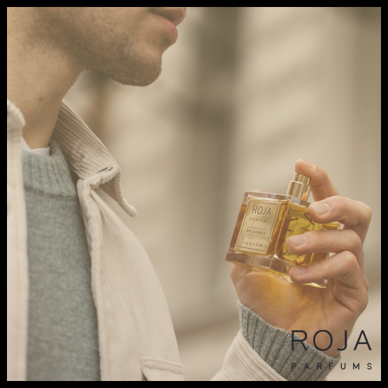 A person applying Roja Parfums fragrance